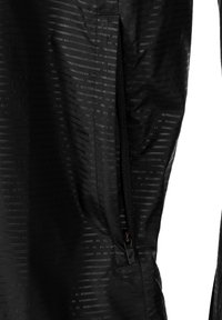 Svart jacka med ett mönstrat tyg med horisontella linjer, en ficka med dragkedja och en slät, lätt textur.