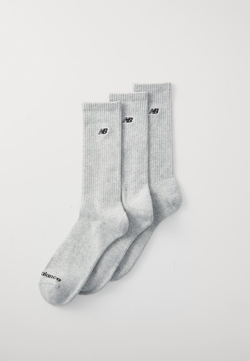 Drei Paare von gerippten grauen Socken, die nahe der Oberseite ein schwarzes Logo haben, mit glatter Textur und Knöchellänge.
