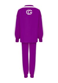 Survêtement violet avec des rayures blanches. Comprend un haut ample avec un col rond et des poignets élastiques, ainsi que des pantalons assortis avec des chevilles élastiques.