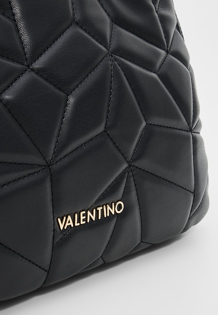 Sac en cuir noir avec un motif de matelassage en losanges et des coutures visibles, orné d'un accent en or avec le logo "VALENTINO" sur le devant.