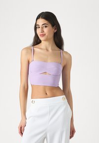 Lilac cropped top with thin straps, structured bust design, and a front cutout detail. Soft material and smooth texture.