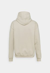 Beżowa bluza z dużym kapturem, opadającymi ramionami i ściągaczami. Gładka tekstura bez widocznych wzorów czy elementów metalowych. Pokazany widok z tyłu.