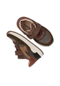 Bruine en grijze sneakers van suede, mesh en textielmaterialen, met een klittenbandsluiting, geperforeerde neus en contrasterende tan accenten.