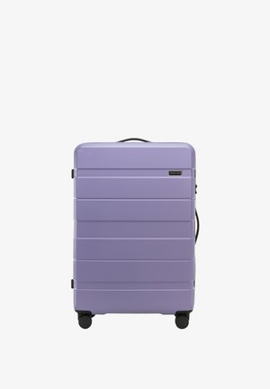 Valigia rigida di colore lavanda, con scanalature orizzontali, maniglia superiore e quattro ruote nere per la mobilità. Logo del marchio sulla parte anteriore.