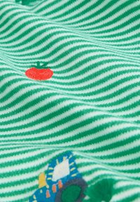 Zeleno-bielo pruhovaná látka s výšivkou červenej paradajky a viacfarebného traktora; mäkká textúra s vlnitým vzhľadom.