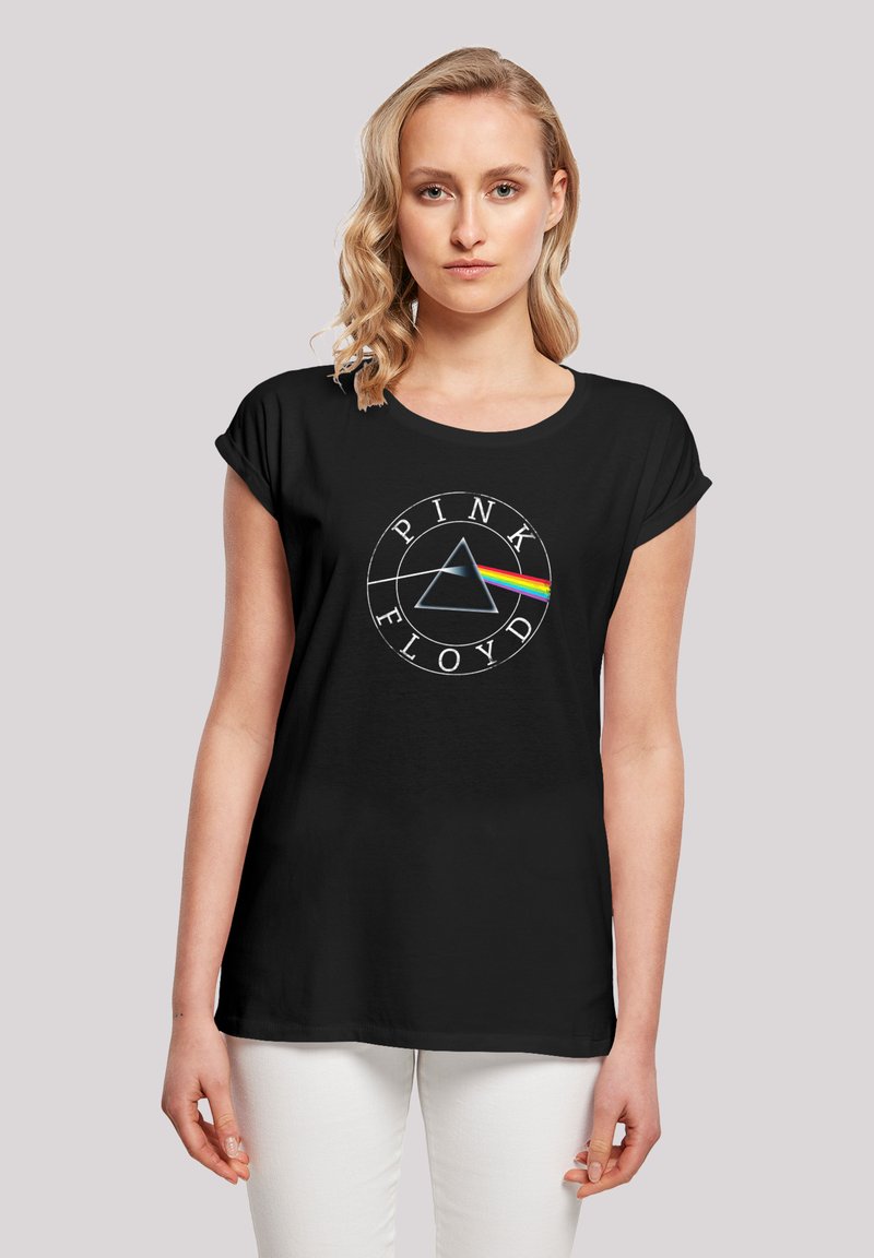 Black t-shirt featuring a circular logo with "PINK FLOYD" text, a triangle, and a rainbow stripe against a soft texture. Short sleeves.