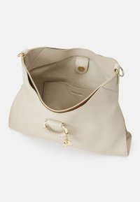 Beżowa skórzana torba na ramię z otwartym wierzchem, złotymi elementami, przednim uchwytem, wewnętrzną kieszenią i zapięciem na magnes, pokazana na białym tle.