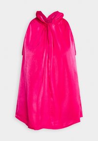 Cape en velours rose vif avec un nœud noué au niveau de l'encolure, suspendue sur un fond blanc.
