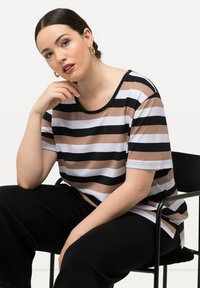 Camiseta de rayas con franjas horizontales en negro, blanco y beige, mangas cortas, escote redondeado y material de algodón suave.
