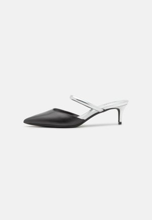 Scarpe slingback in pelle nera con punta affilata, dotate di una cinghia alla caviglia argentata e di un tacco metallico basso. Finitura testurizzata sul materiale.