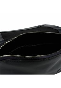 Borsa in pelle nera con chiusura a zip, con un'esterno liscio, rivestimento interno morbido e dettagli in metallo sulla zip.