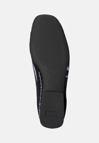 Black shoe sole featuring textured grip patterns, with a colorful knit upper partially visible on the sides.