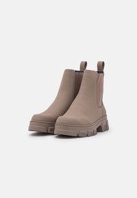 Gray rubber ankle boots with elastic side panels, rounded toe, and chunky sole featuring deep treads. Loop tabs for easy wear.