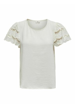 Hvit kortermet bluse med pufferm, med broderte blonde detaljer og teksturert stoff. Rund hals, avslappet passform.