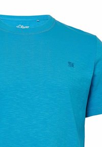 Kurzarm-T-Shirt in leuchtendem Blau, aus strukturiertem Stoff gefertigt. Verfügt über ein kleines Logo auf der Brust und einen gerippten Ausschnitt.