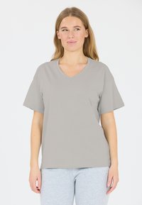 Grå V-ringad t-shirt i mjukt tyg, med korta ärmar och avslappnad passform. Tillsammans med grå sweatpants.