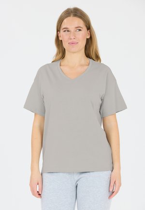Grå V-hals t-shirt lavet af blødt stof, med korte ærmer og en afslappet pasform. Båret med grå sweatpants.