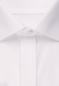 Kołnierzyk białej koszuli zapięty na górny guzik i staranne przeszycia na krawędziach.