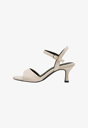 Sandale en cuir beige avec une large bande avant, une bride de cheville ajustable, et un talon aiguilles de 5 cm. Texture lisse et design minimaliste.
