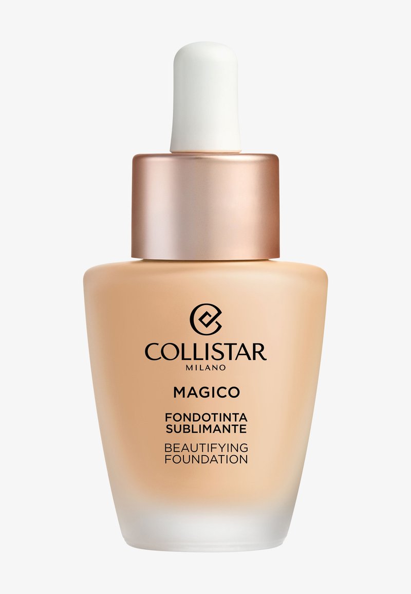 Fond de teint embellisseur Magico de Collistar dans un flacon en verre transparent à base ronde, liquide beige clair, compte-gouttes blanc et bouchon en or rose.