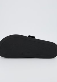 Suola di sandal nero con gomma texturizzata, marchio impresso "paul green" e design minimalista con forma piatta.