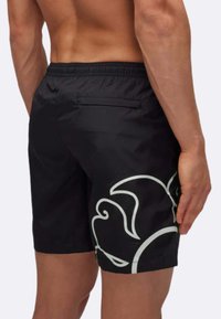 Shorts da nuoto neri con un elastico in vita, caratterizzati da un grande motivo a spirale bianca sul lato e una tasca posteriore. Tessuto leggero.