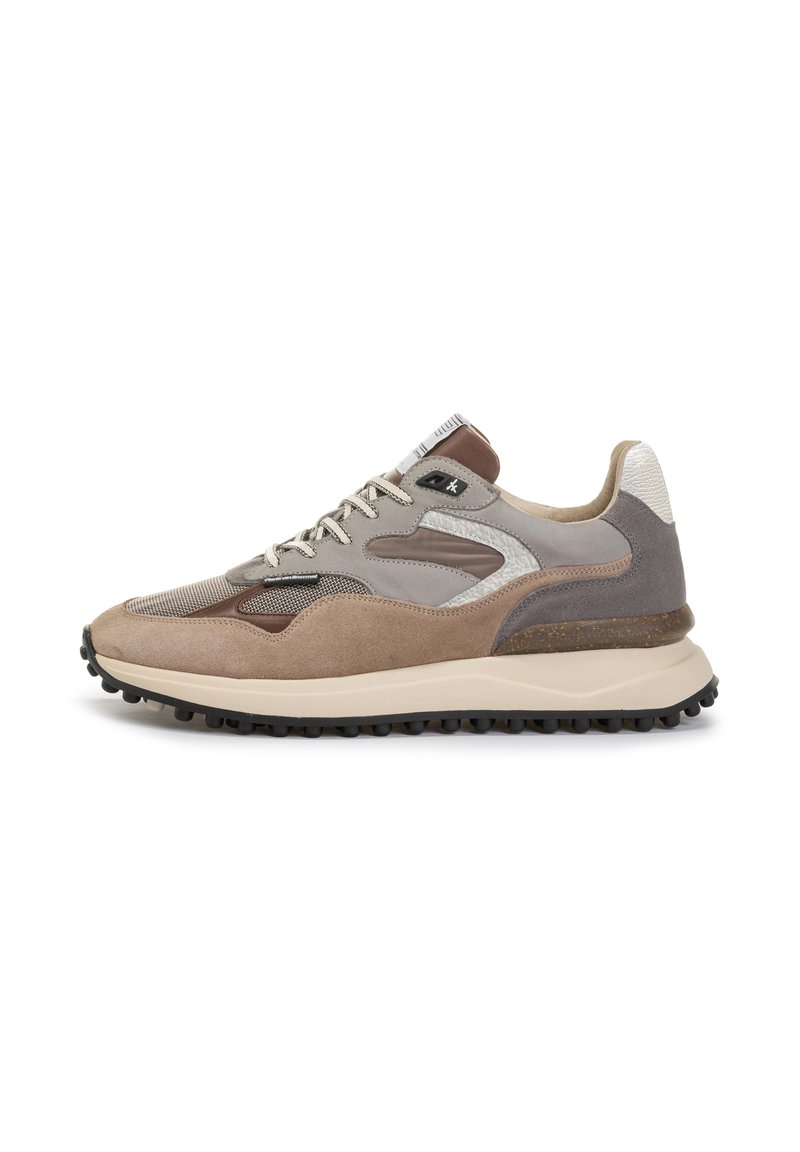 Zapatilla marrón y gris con una mezcla de materiales de ante y malla, forma redondeada, detalles texturizados y suela de goma con agarres de tracción.