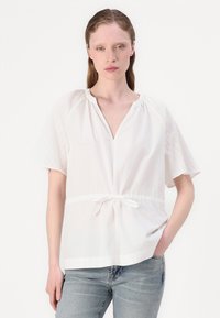 Weißes Blusenshirt mit kurzen Ärmeln, V-Ausschnitt und elastischem Kordelzugbund. Verfügt über strukturierte Seitenpaneele und glattes Material.