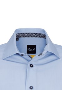 Camicia azzurro chiaro con colletto classico, chiusura con bottoni scuri e dettagli a fantasia all'interno del colletto. Etichetta della taglia "38" visibile.