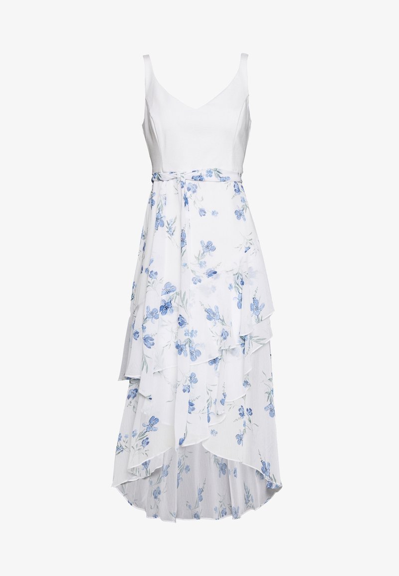 Robe blanche sans manches avec col en V, jupe asymétrique à volants et motif floral bleu clair avec un lien assorti à la taille.