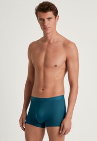 Turquoise boxershorts gemaakt van zachte stof, met een comfortabele pasvorm, middelhoge taille en een elastische tailleband met het logo van het merk.