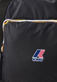 Černá látková taška s přední kapsou lemovanou bílou a oranžovou paspulí, která má modro-červené logo K-WAY.