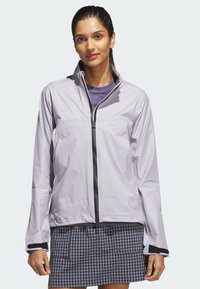 Light purple waterproof jacket with a high collar, black zipper, and Velcro cuffs, worn over a purple shirt and a checkered skirt.