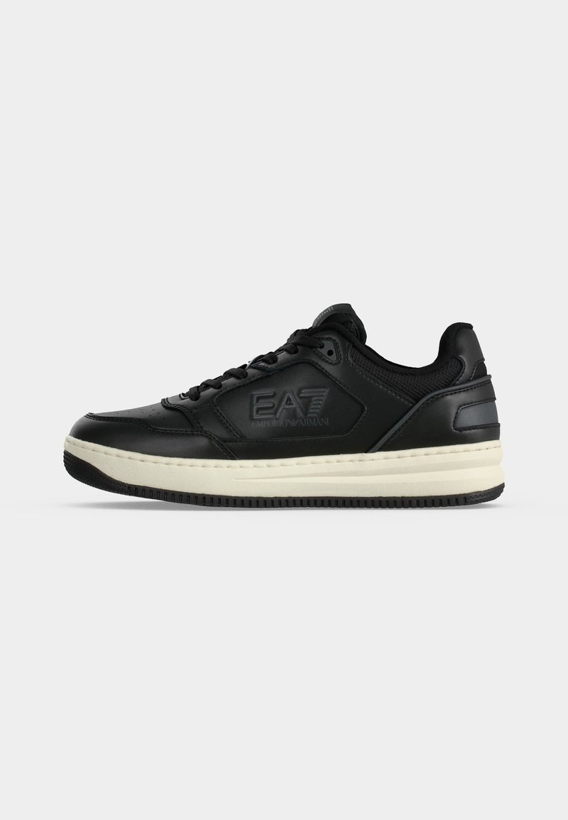 Μαύρο sneaker χαμηλού τύπου με κορδόνια, λευκή σόλα και λογότυπο EA7 Emporio Armani στο πλάι, εμφανίζεται σε απλό φωτεινό φόντο.