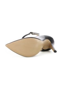 Scarpa nera in vernice con tacco alto, punta affusolata, cinturino sottile alla caviglia e suola beige testurizzata.