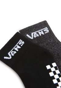 Calze lavorate a maglia nere e grigie con logo Vans bianco. La calza nera presenta un motivo a scacchi vicino alla caviglia; la calza grigia è tinta unita con il logo in alto.