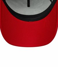 Rote Kappe mit einem schlichten Design, flachem Schirm und einem schwarzen Akzent am Rand. Das Innere ist hellgrau mit sichtbarem Nähmuster.