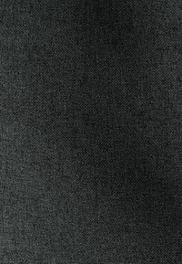 Vue en gros plan d’un tissu gris foncé avec une texture étroitement tissée et un motif discret en quadrillage.