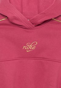 Hanorac bordeaux cu un logo "nike" brodat în aur. Dispune de o buzunar frontal, glugă cu șnur și un material moale, texturat.