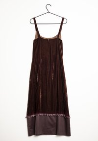 Sammetklänning i mörkbrun med tunna axelband, med plisséer och en pärlfrans vid fållen, samt ett kontrasterande tyg i botten.