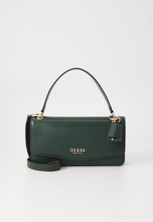 Green faux leather handbag with a short handle, gold brand logo, a detachable tag, and an optional crossbody strap. Smooth texture.