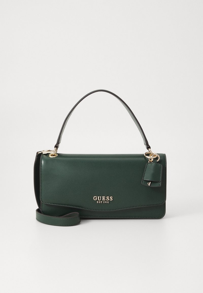 Green faux leather handbag with a short handle, gold brand logo, a detachable tag, and an optional crossbody strap. Smooth texture.