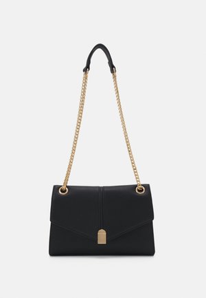 Sac à main en cuir noir avec une bandoulière en chaîne dorée, présentant un rabat pliant, une forme rectangulaire et un design légèrement structuré.
