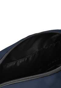 Borsa in tessuto blu navy con una superficie liscia e chiusura con zip. L'interno è nero con una tasca per l'organizzazione. Design semplice e funzionale.