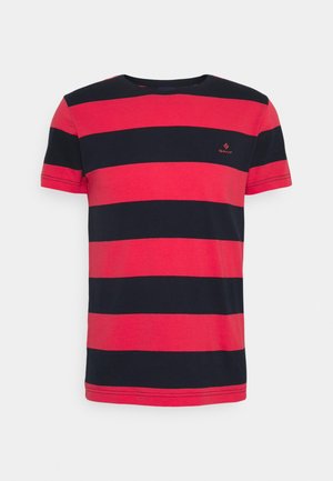 T-shirt rayé rouge et marine en coton, avec col rond et manches courtes. Comprend un petit logo brodé sur la poitrine.