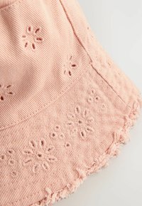 Pink Cord-Stoff Bucket-Hut mit floraler Stickerei und fransigen Kanten. Das Design umfasst eine strukturierte Form und eine texturierte Oberfläche.