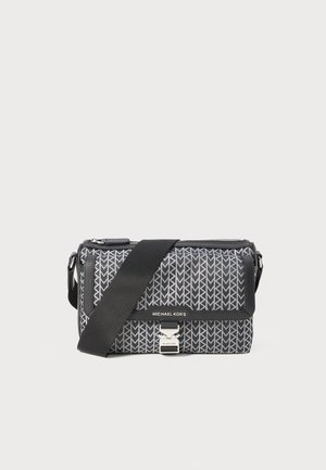 Sac bandoulière à motifs noir et gris avec un design géométrique, fermeture zippée et accent en métal argenté. Sangle ajustable incluse.
