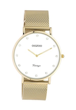 Montre vintage OOZOO en or avec cadran blanc, index en cristal et bracelet en maille dorée affichant l'heure 10:10.