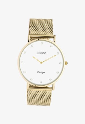Montre vintage OOZOO en or avec cadran blanc, index en cristal et bracelet en maille dorée affichant l'heure 10:10.