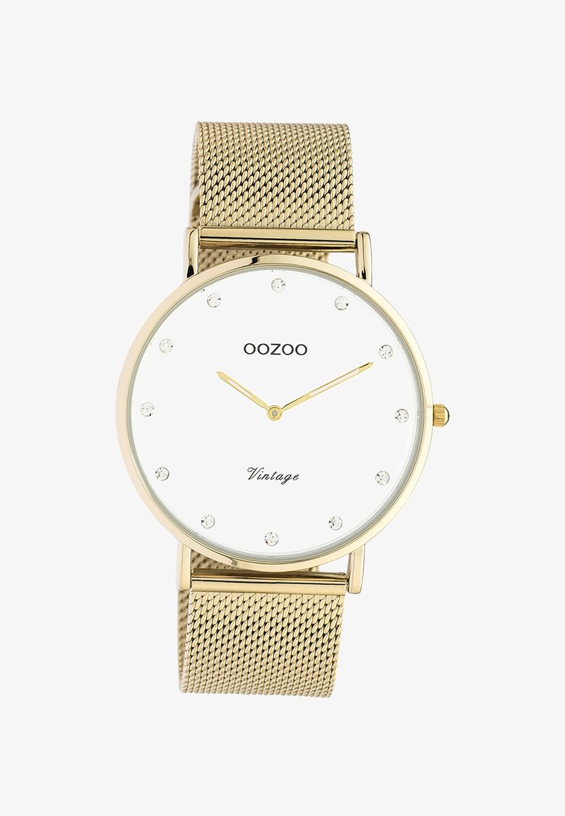 Montre vintage OOZOO en or avec cadran blanc, index en cristal et bracelet en maille dorée affichant l'heure 10:10.